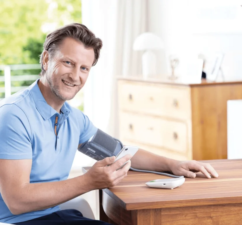 Man measuring blood pressure with a connected monitor