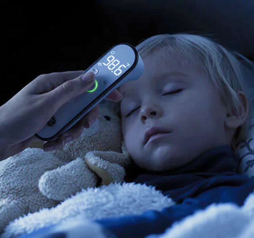 Parent taking a sleeping child's temperature
